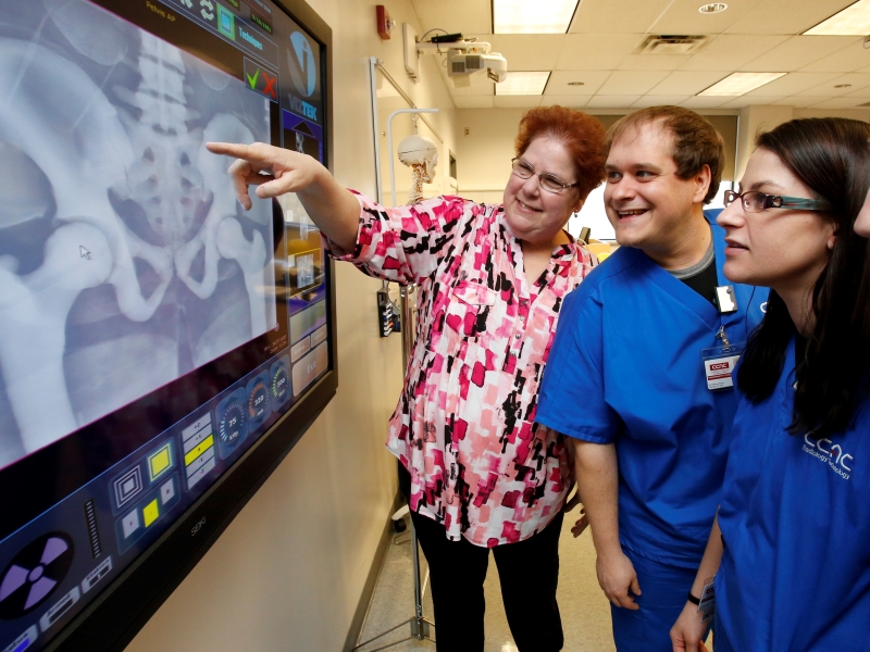 CCAC students in the Radiologic Technologist program examine an X-Ray alongside an instructor.