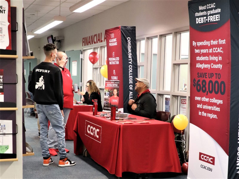 CCAC staff greet students with tables of resources during an Open House event.