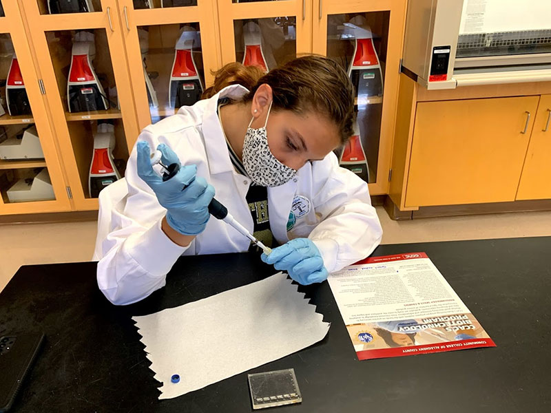 A high school student in the Healthcare Careers Academy practices using laboratory equipment as part of the program's educational activities.