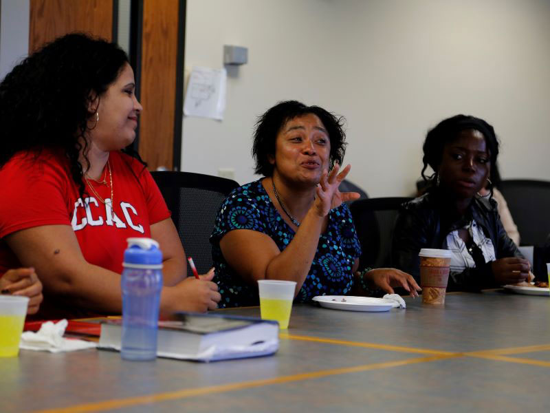 Several CCAC students are seated at a table where a lively discussion is in progress.