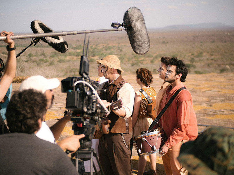 Actors and film crew shooting a scene outdoors.